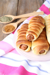 Baked sausage rolls on plate on table close-up