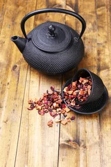 Foto op Aluminium Black teapot, bowl and hibiscus tea on color wooden background © Africa Studio