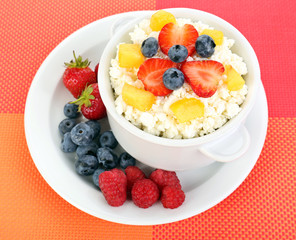 Cottage cheese with fruits and berries in bowl on table