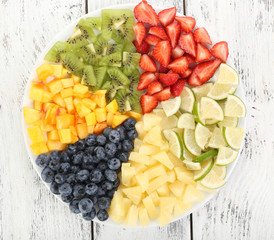 Sliced fruits on plate on wooden table