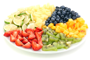 Sliced fruits on plate isolated on white