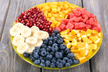 Sliced fruits on plate on wooden table