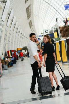 young business travelers man and woman walking in a public station