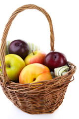 Assortment of juicy fruits in wicker basket, isolated on white