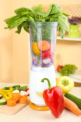 Blender with fresh vegetables on kitchen table