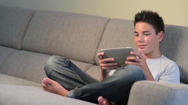 Teenager- Young boy playing from digital tablet