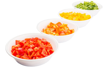 Fototapeta na wymiar Colorful chopped capsicums in white bowls over white background