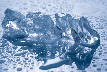 Melting ice, drops of water on white