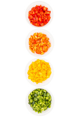 Colorful chopped capsicums in white bowls over white background