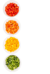 Colorful chopped capsicums in white bowls over white background