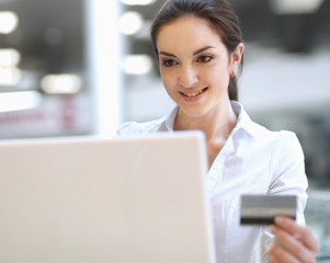 Woman sitting the desk and shopping online isolated on white