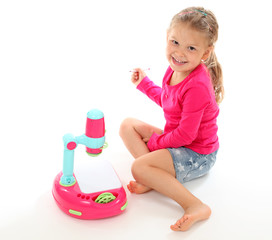 Little girl playing with a toy projector. Isolated over white