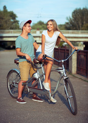 Obraz premium Happy couple riding a bicycle in the city street