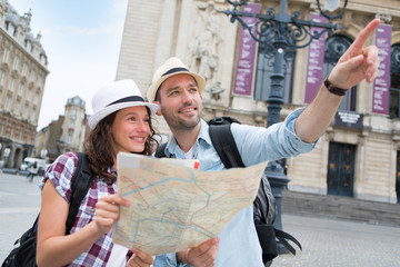 Couple of young attractive tourists watching map