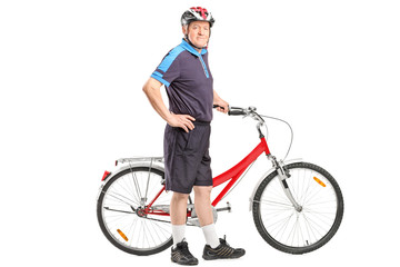 Active senior pushing a bicycle and posing