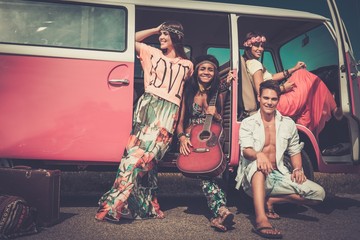 Multi-ethnic hippie friends with guitar on a road trip