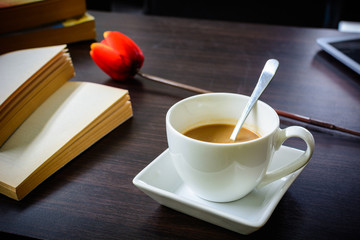 cup of coffee with tulip and book