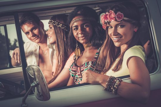 Multi-ethnic hippie friends in a minivan on a road trip