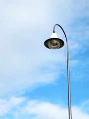 Outdoor public lighting pole with blue sky on background