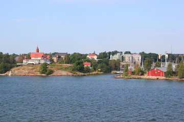 Rote Holzhäuser auf Schären vor dem Hafen von Helsinki