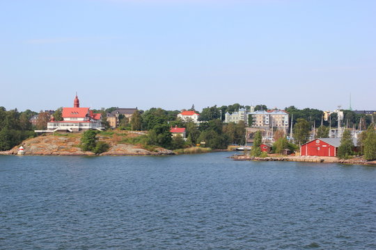 Rote Holzhäuser auf Schären vor dem Hafen von Helsinki