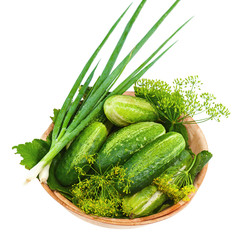 Cucumbers and vegetables and dill leaves still life in wooden bo