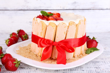 Tasty cake Charlotte with fresh strawberries on wooden table