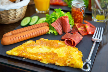 Scrambled eggs, sausages and bacon with salad breakfast