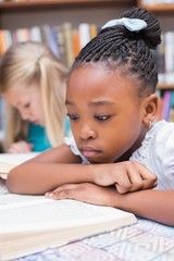 Cute pupils reading books in library