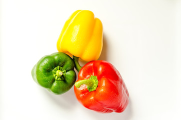 Paprika rot gelb gruen nebeneinander auf weiss