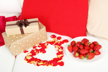 Romantic still life with strawberry, gifts and petals of roses