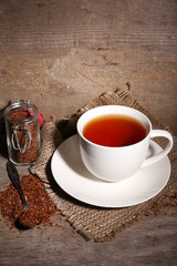 Cup of tasty rooibos tea, on wooden table