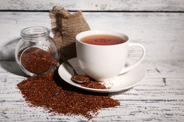 Cup of tasty rooibos tea, on old white wooden table