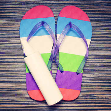 color flip-flop and beach items on wooden background