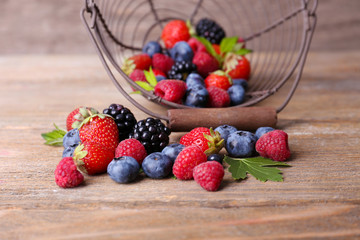 Ripe sweet different berries in metal basket,