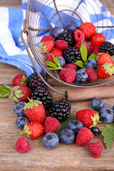 Ripe sweet different berries in metal basket,