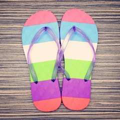 Pair of striped flip-flop on wooden deck. Top view.
