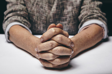 Fototapeta premium Praying hands of a senior woman
