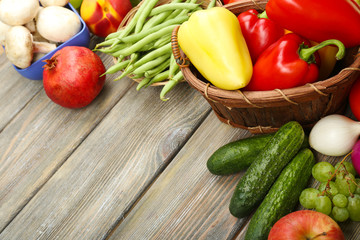 Fresh organic vegetables and fruits on wooden background