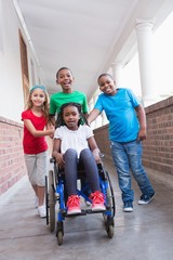 Cute disabled pupil smiling at camera in hall with her friends