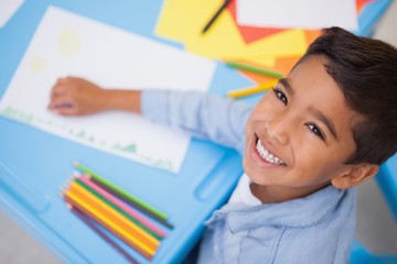 Cute little boy drawing at desk