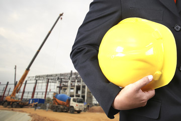 engineer holding yellow helmet for workers security on buildings