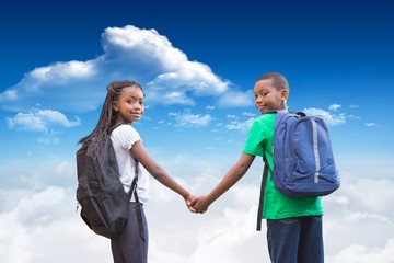 Composite image of cute pupils holding hands