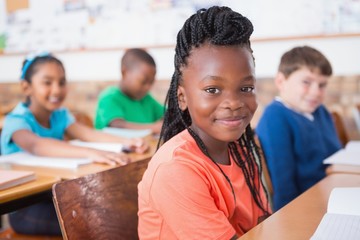 Cute pupils listening attentively in classroom