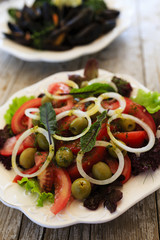 Mediterranean salad and mussels on plate