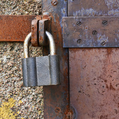 Old metal door closed with a lock