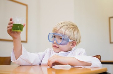 Fototapeta na wymiar Cute pupil dressed up as scientist in classroom