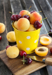 Naklejka na ściany i meble Fresh apricot and cherry in a bucket