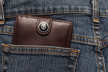 brown leather wallet in the pocket of jeans