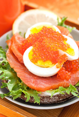 Sandwich with salted salmon, egg and red caviar